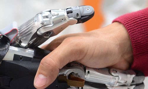 Plan serré recadré d'une poignée de main entre un robot et un humain dans un laboratoire