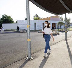 Jeune lycéenne portant un masque de protection et marchant dans l'enceinte du Lycée des Bourdonnières